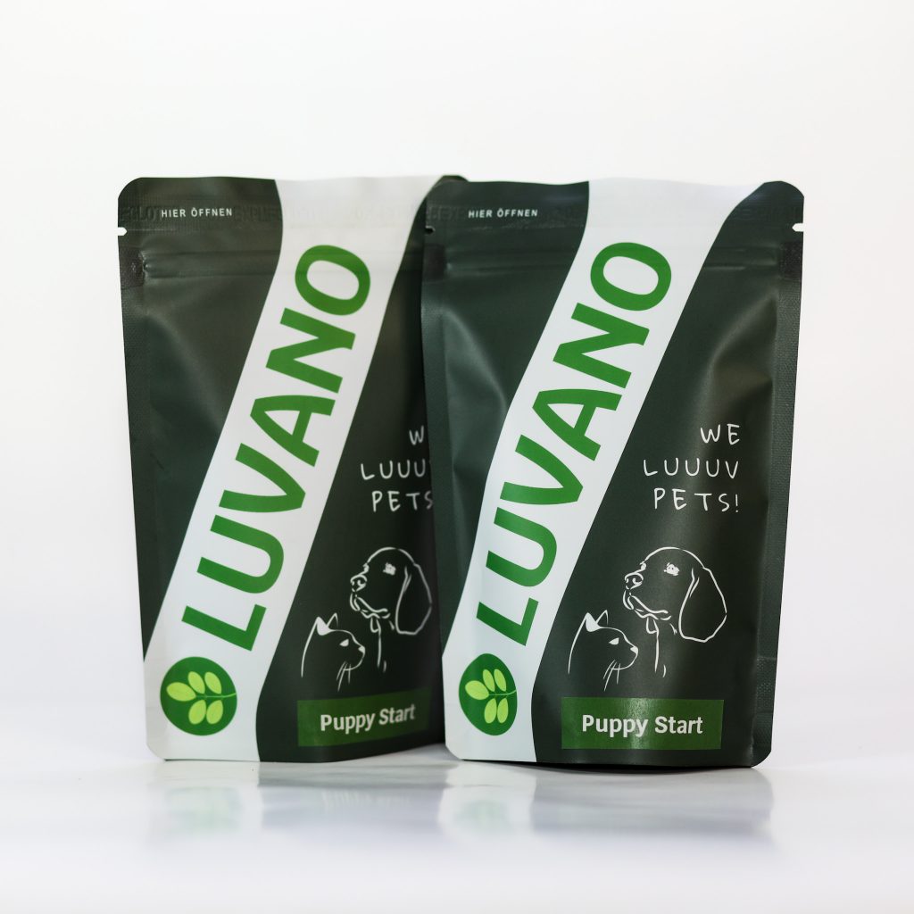 Zwei Standbeutel Luvano Puppy Start Pulver für Welpen vor hellem Hintergrund